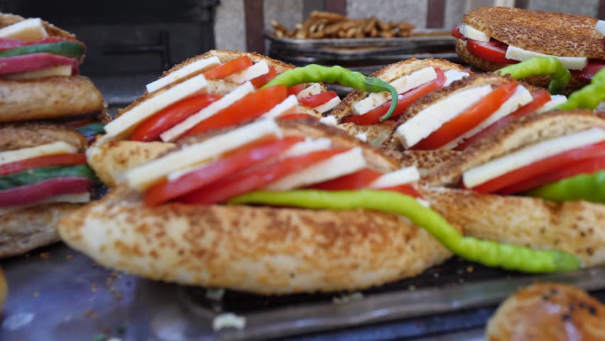 Traditional delicious Turkish street food; Izmir cesme kumru sandwich made of cheese, soudjouk, salami, soudjouk, tomato and pepper