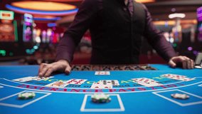 Online Casino: Professional Croupier Deals Cards on Blackjack Table: Anonymous Male Game Dealer Masterfully Revealing possible Jackpot Winning Hand, Excitement in High Stakes Game. Closeup Static shot - Powered by Shutterstock - Get 15% off with code: PIKWIZARD15