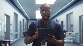 Following Shot of a Male Doctor with Positive Attitude, Calmly Walking Through Hospital Hallway, Using Digital Tablet, Greeting Nurses and His Colleagues. Bright Modern New Clinic - Powered by Shutterstock - Get 15% off with code: PIKWIZARD15
