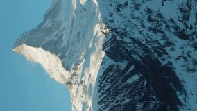 Matterhorn Mountain in Winter Day. Switzerland in Snow. Aerial View. Medium Shot. Drone Flies Sideways, Camera Tilts Up. Vertical Video