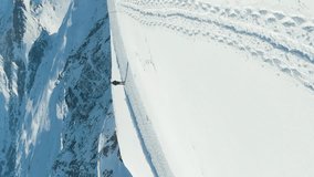 Blue Matterhorn Mountain in Winter Day and Hiker Man. Switzerland. Aerial View. Reveal Shot. Drone Flies Forward, Camera Tilts Up. Vertical Video