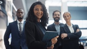 Posing Shot of a Diverse Group of Talented Young Business People Standing in the Modern Office Environment. Successful Team Smiling on Camera, Led by a Confident Female CEO. Slow Motion - Powered by Shutterstock - Get 15% off with code: PIKWIZARD15