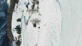 Matterhorn Mountain and Skiers on Piste in Winter Day. Swiss Alps, Switzerland. Aerial View. Drone Flies Forward, Camera Tilts Up. Reveal Shot. Vertical Video