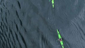 Two Green Kayaks in Turquoise Water of the Geiranger Fjord. Norway. Aerial Vertical Top-Down View. Drone is Flying Sideways. Vertical Video
