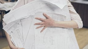 Young woman holding pile of blueprints