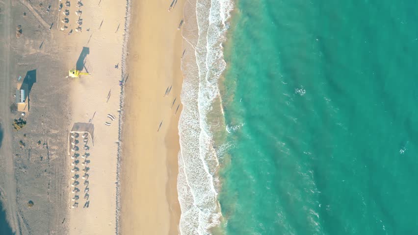 Summer seascape beautiful waves, blue sea water in sunny day. Esquinzo beach, Spain, Canary Island Top view from drone. Sea aerial view, tropical nature Beautiful bright sea waves
