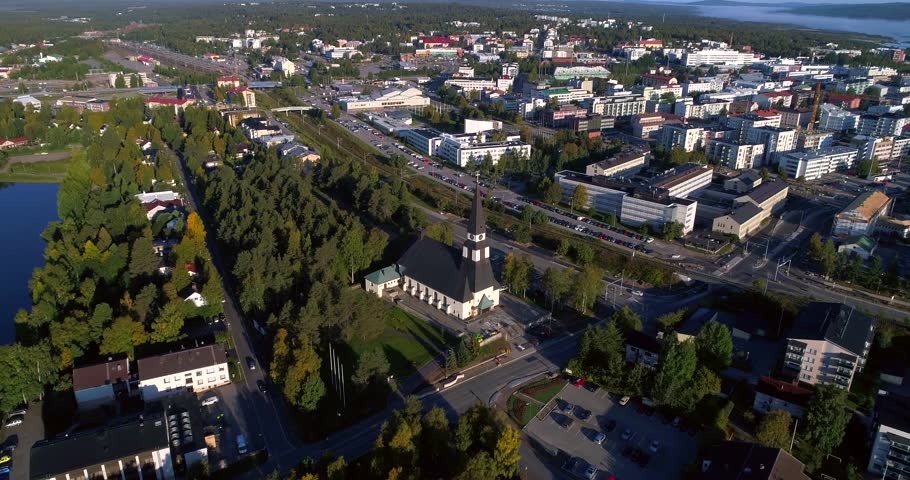 Arctic city, Cinema 4k aerial tilt view towards a church and Rovaniemi city, above kemijoki river, on a sunny autumn morning dawn, in Lapland, Lappi, Finland