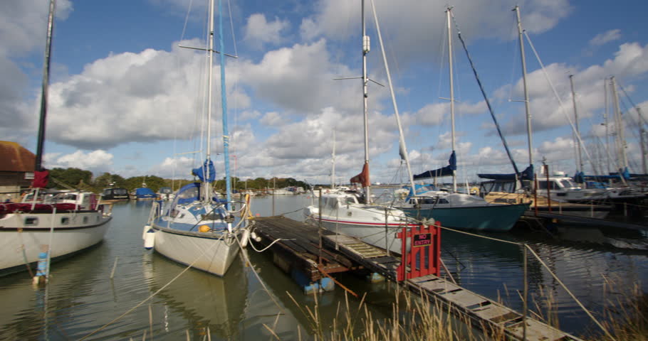 Planning shot of sailboats moored up at high tide at Ashlett creek sailing club in the Solent, Southampton Royalty-Free Stock Footage #3402112449