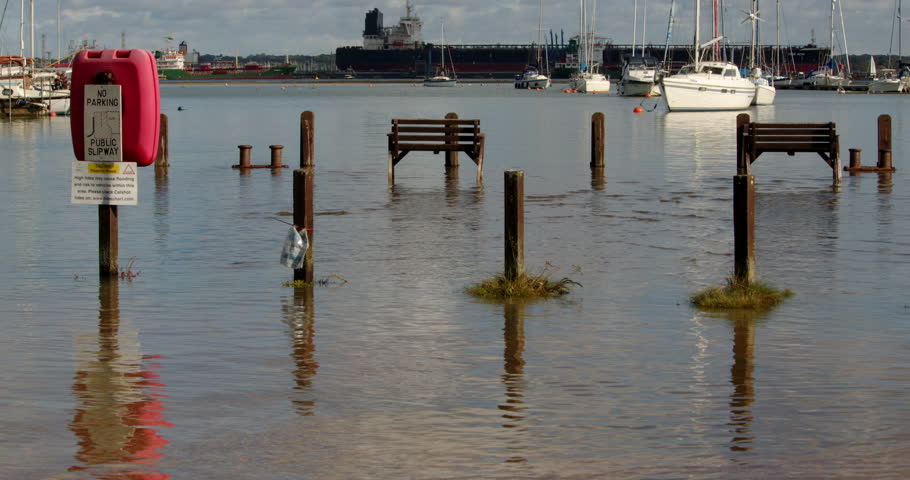 wide shot of benches and pathway flooded at high tide at Ashlett creek in the Solent, Southampton Royalty-Free Stock Footage #3402112723