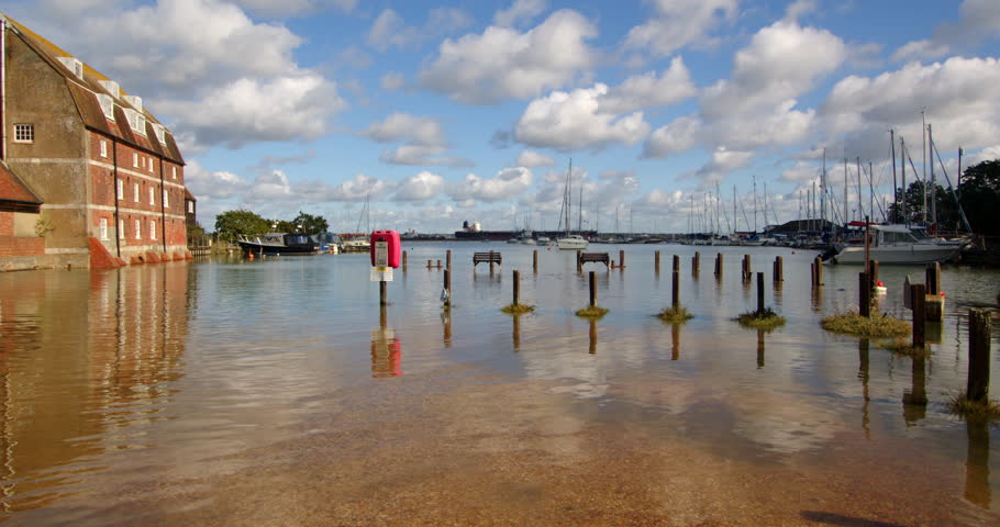 extra wide shot of water mill with benches and pathway flooded at high tide at Ashlett creek in the Solent, Southampton Royalty-Free Stock Footage #3402114547