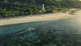 Pandawa beach with scenic landscape, lighthouse and fishing boat in ocean at Bali island.