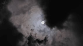 full moon moving between clouds. Vertical video