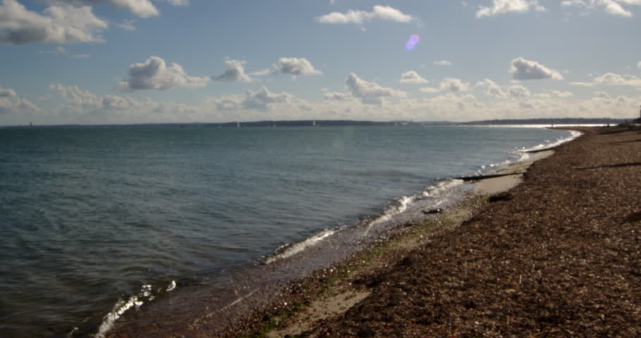 shot of the shingle beach looking towards the Isle of Wight at Calshot spit by the Solent, Southampton Royalty-Free Stock Footage #3402123829