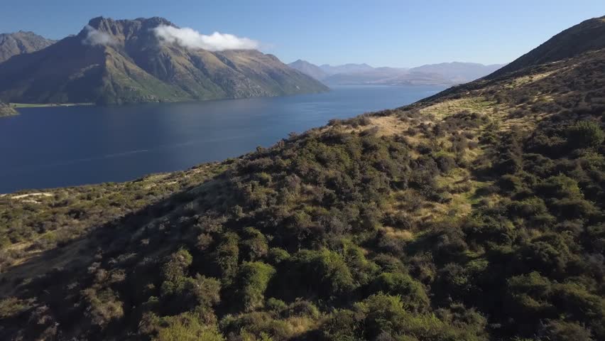 Aerial UHD tracking shot over a mountain peak near Queenstown New Zealand Royalty-Free Stock Footage #3402145749