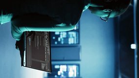 Vertical video Engineer walking in server room housing advanced infrastructure storing massive datasets. Worker running code on tablet to upgrade data center rigs doing complex computational - Powered by Shutterstock - Get 15% off with code: PIKWIZARD15