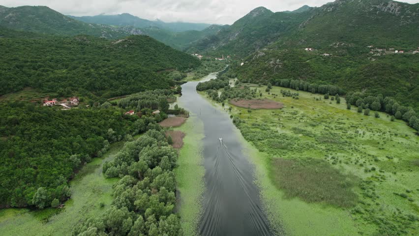 Aerial footage captures the stunning view of the horseshoe-shaped river bend at Pavlova Strana near Skadar Lake in Montenegro. The footage provides a mesmerizing view of the natural beauty in 4K.  Royalty-Free Stock Footage #3402497751