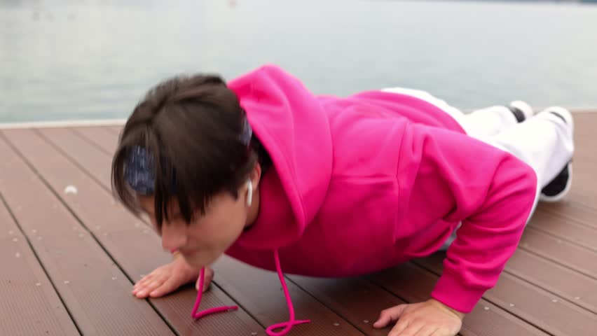 Strong athlete does push-ups near lake.Athlete fitness training push-ups nature
