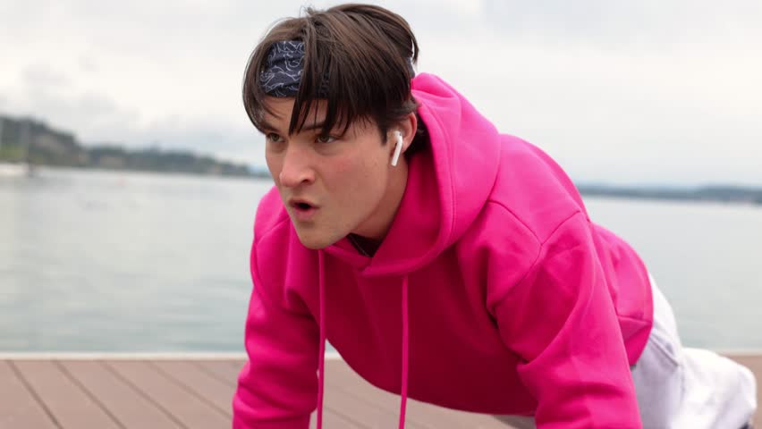 Strong athlete does push-ups near lake.Athlete fitness training push-ups nature