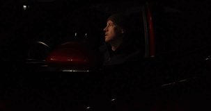Video clip of an adult male behind the wheel of his car, just pulled over by the police, hurrying to put on his seat belt before the officer arrives