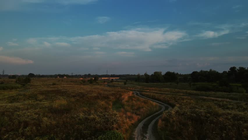 Rural Dusk: Power Pylons Stretching Across the Fields