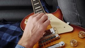 Hands playing on electric guitar ballad pop rock song. Guitarist performing song on guitar, playing on strings, close up. Playing on music instruments. Guitar lessons. Music concept. Vertical video
