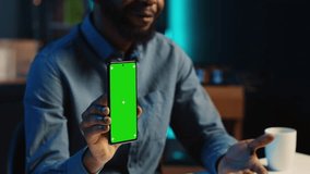 Content creator films chroma key smartphone video review for tech enthusiasts, close up. Viral online star hosts technology internet show, unboxing isolated screen cellphone, focus on product
