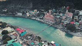 An aerial view of the beautiful holy Ganga river, Lakshman Jhula bridge, Tera Manzil Temple, and Trimbakeshwar. Rishikesh is a holy town and a popular travel destination in India.