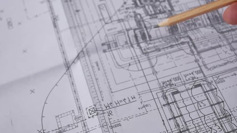 Macro close up of quantity surveyors hand reviewing technical drawing. Architect working on blueprint. Construction concept. Engineering tools. Top view.