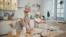 Grandma granddaughter cooking at home. Family senior grandmother teaching child girl baking making dough sprinkling flour together on kitchen. Cook culinary cuisine bakery preparing food bake concept. - Powered by Shutterstock - Get 15% off with code: PIKWIZARD15