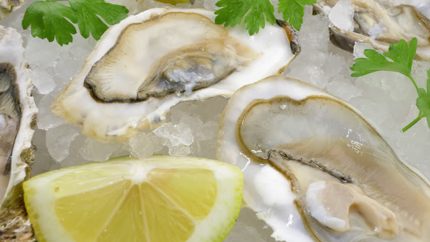 Raw Pacific oysters with lemon on crushed ice. Royalty-Free Stock Footage #3403042919