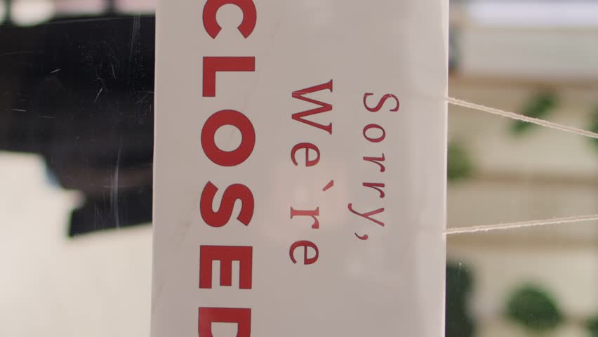Vertical video Trendy clothing store being closed at night after finished working hours. Extreme close up shot on sorry we are closed message sign on fashion boutique door in mall at shift end