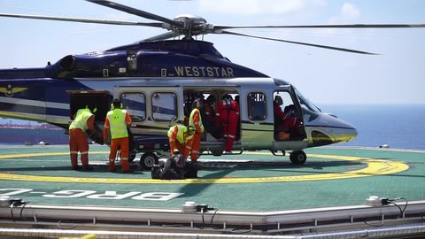 KELANTAN, MALAYSIA - NOVEMBER 16th, 2017 : Unidentified Helicopter Landing Officer (HLO) and team loading the luggage inside Agusta Westland AW 139 for offshore workers who signed off from duties.