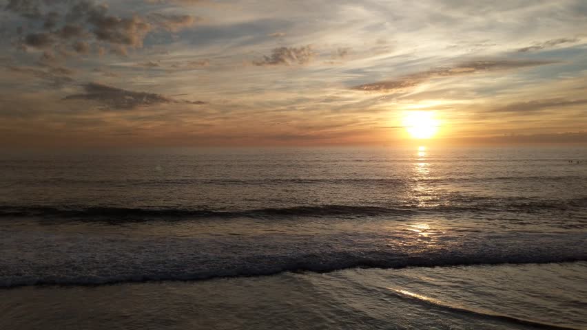 Sunset over Pacific shore waves at Swamis Reef Surf Park Encinitas California.