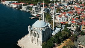 aerial drone video of the Ortaköy Mosque or Büyük Mecidiye Camii in Beşiktaş, Istanbul, Turkey during a sunny day on the side of bosphorus