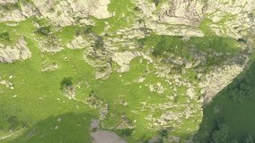 Rocky cliff and green hills. Aerial view. Vertical shot. Vertical Video