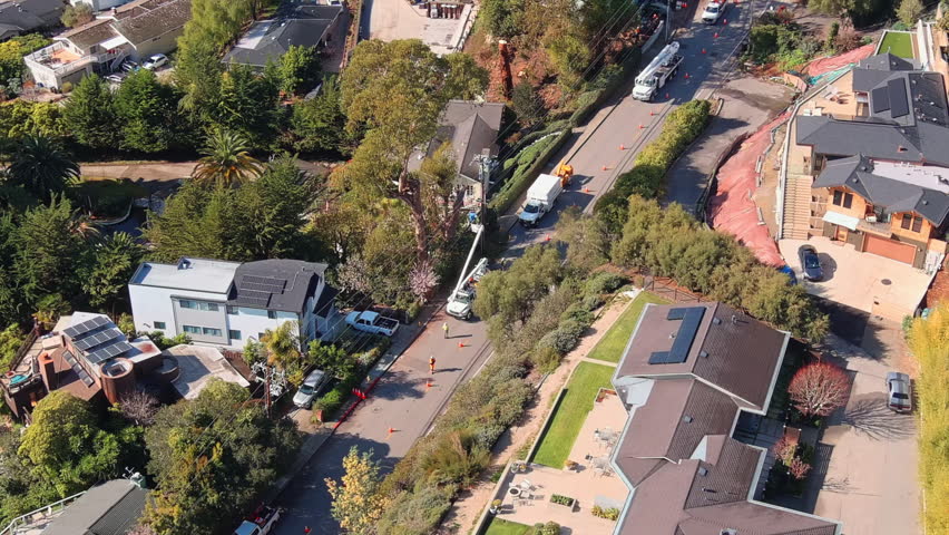 Cinematic topdown view of power line maintenance in inviting suburb. Santa Cruz, California