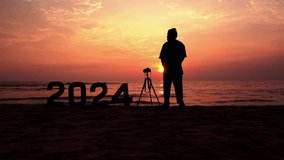 Travel Photographer enjoying sunset view at beach with 2024 New Year sign, New Year photography concept video clip, Successful New Year background