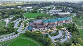 High aerial view of large American high school with line of yellow school buses during dismissal. - Powered by Shutterstock - Get 15% off with code: PIKWIZARD15