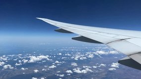 plane wing, Airplane flight above clouds and land. side view from window of plane flying on clouds. Traveling by air, vacation concept. wing of Airplane from window View. Passenger seat POV 4k video
