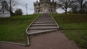 View of the Church of the Sign of the Blessed Virgin Mary in Dubrovitsy (Russia, Podolsk) and stone staircase in cloudy autumn day. Soft focus. Real time handheld video. Religious architecture theme.