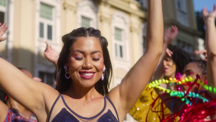 Joyful Celebration at Brazilian Street Carnaval, Energetic Woman with Vivacious Friends Dancing. Exuberance and Festivity with Carnival Costumes in Brazil. Royalty-Free Stock Footage #3403553165
