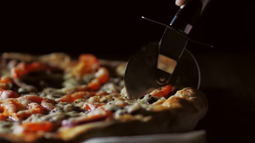 Process, stages of cooking pizza. juicy, mouth-watering pizza is cut with a metal pizza cutter on wooden background. | Shutterstock HD Video #34035547