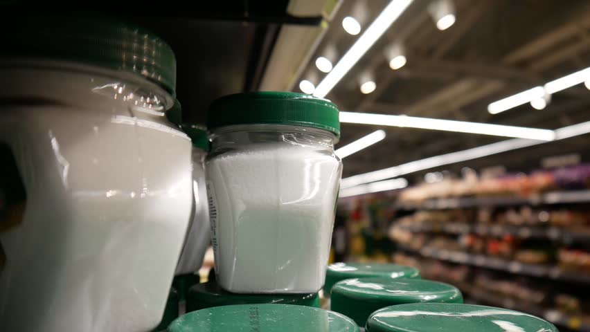Close-up of many jars of salt on the shelf of a supermarket and a male buyer's hand takes it Royalty-Free Stock Footage #3403599979