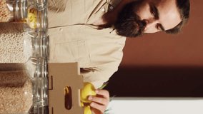 Vertical video Man in low carbon footprint store feels dopamine rush while smelling lemons. Customer in local neighborhood grocery shop has nostalgic bliss moment seeing farm grown fruits, remembering