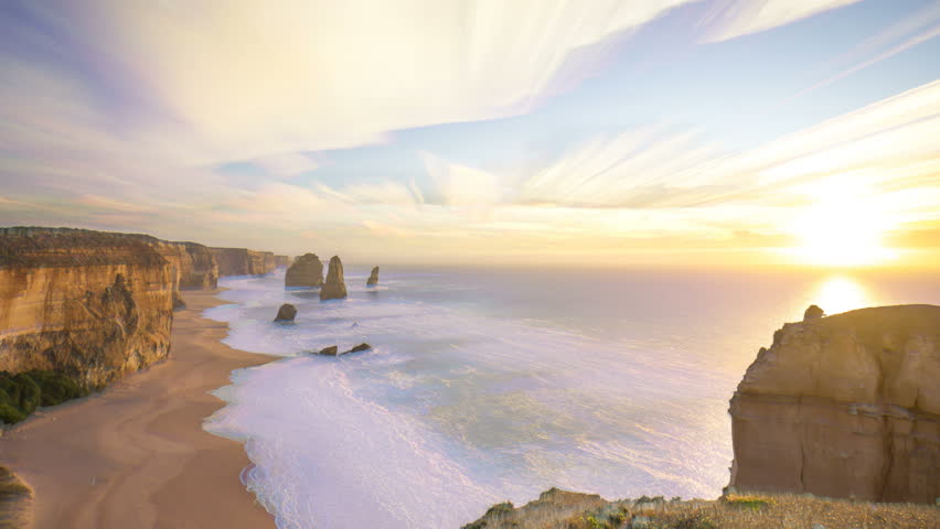 Time lapse of sunrise at beautiful rock formation along the coastline - The 12 Apostles, Port Campbell, Victoria Australia. Time lapse with brush stroke and long exposure effect. Zoom out
