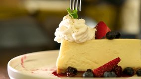 Strawberry cheesecake served on plate on dim wooden table foundation. Video 