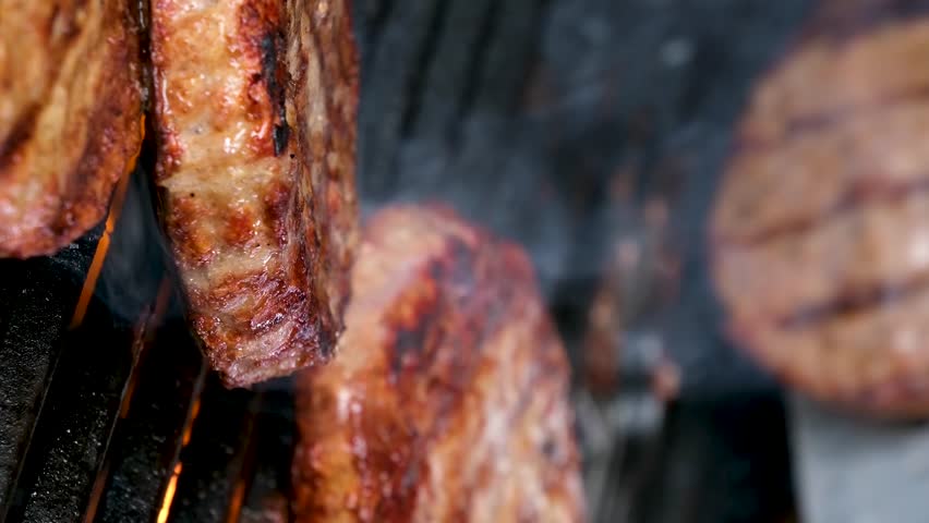 Delicious juicy meat steaks cooking on the grill on fire. Aged prime rare roast grilling tenderloin fresh juicy beef filet with lines slow motion. Grill, tasty beefsteak close up Royalty-Free Stock Footage #3403961537