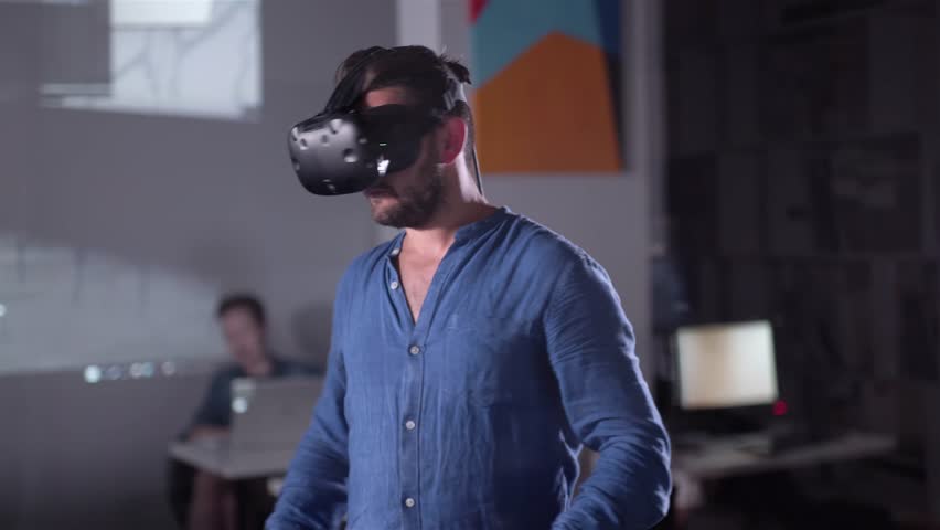 Architect Engineer Using Virtual Reality Software for His Project. Man with Headset and Controllers wearing VR headset for working design 3D architectural building model with BIM technology and - Powered by Shutterstock - Get 15% off with code: PIKWIZARD15