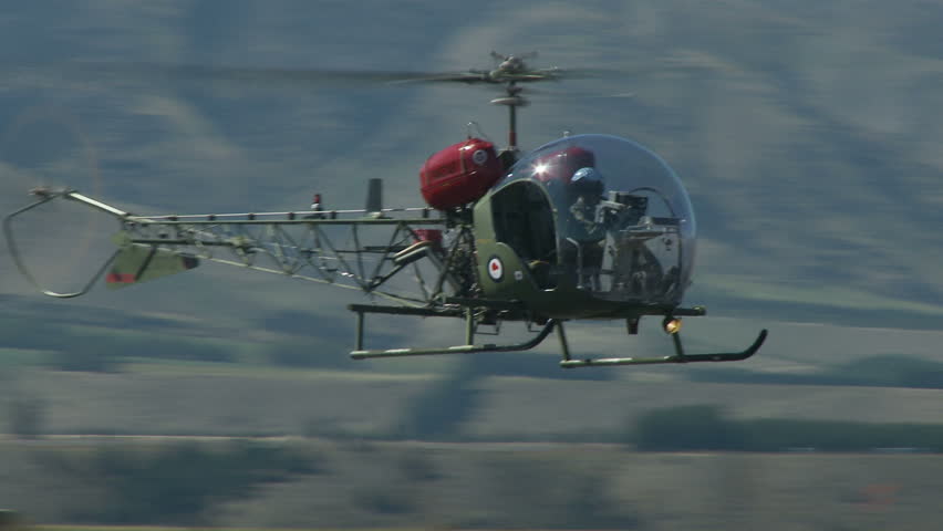 A Sioux helicopter hovering and moving laterally from right to left