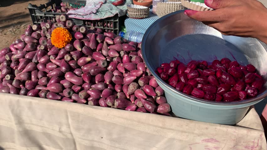 A pile of red prickly pears (cactus fruit) for sale in a street cart. Close-up of exotic red cactus fruit. A prickly pear seller